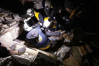 Syrian rescuers (White Helmets) retrieve an injured man from the rubble of a collapsed building  follwoing an earthquake, in the border town of Azaz in the rebel-held north of the Aleppo province, early on February 6, 2023, - At least 42 have been reportedly killed in north Syria after a 7.8-magnitude earthquake that originated in Turkey and was felt across neighbouring countries. (Photo by Bakr ALKASEM / AFP) (Photo by BAKR ALKASEM/AFP via Getty Images)