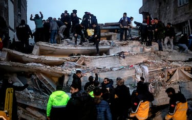 epa10450296 Turkish emergency personnel and others try to help victims at the site of a collapsed building after an earthquake in Diyarbakir, Turkey 06 February 2023. According to the US Geological Service, an earthquake with a preliminary magnitude of 7.8 struck southeast Turkey close to the Syrian border. The earthquake caused buildings to collapse and sent shockwaves over northwest Syria, Cyprus, and Lebanon.  EPA/REFIK TEKIN