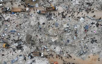 IDLIB, SYRIA - FEBRUARY 06: An aerial view of a collapsed buildings as personnel and civilians conduct search and rescue operations in Idlib, Syria after 7.7 and 7.6 magnitude earthquakes hits Turkiye's Kahramanmaras, on February 06, 2023. As a result of the earthquake, at least 968 people lost their lives in different parts of Syria, and more than 2,403 were injured. Early Monday morning, a strong 7.7 earthquake, centered in the Pazarcik district, jolted Kahramanmaras and strongly shook several provinces, including Gaziantep, Sanliurfa, Diyarbakir, Adana, Adiyaman, Malatya, Osmaniye, Hatay, and Kilis. Later, at 13.24 p.m. (1024GMT), a 7.6 magnitude quake centered in Kahramanmaras' Elbistan district struck the region. Earthquakes had affected several provinces in Syria's Idlib, Aleppo, Hama, Latakia, Tartus and Raqqa. (Photo by Izzeddin Kasim/Anadolu Agency via Getty Images)