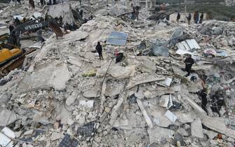 IDLIB, SYRIA - FEBRUARY 06: An aerial view of a collapsed buildings as personnel and civilians conduct search and rescue operations in Idlib, Syria after 7.7 and 7.6 magnitude earthquakes hits Turkiye's Kahramanmaras, on February 06, 2023. As a result of the earthquake, at least 968 people lost their lives in different parts of Syria, and more than 2,403 were injured. Early Monday morning, a strong 7.7 earthquake, centered in the Pazarcik district, jolted Kahramanmaras and strongly shook several provinces, including Gaziantep, Sanliurfa, Diyarbakir, Adana, Adiyaman, Malatya, Osmaniye, Hatay, and Kilis. Later, at 13.24 p.m. (1024GMT), a 7.6 magnitude quake centered in Kahramanmaras' Elbistan district struck the region. Earthquakes had affected several provinces in Syria's Idlib, Aleppo, Hama, Latakia, Tartus and Raqqa. (Photo by Izzeddin Kasim/Anadolu Agency via Getty Images)