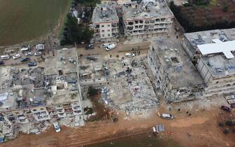 ALEPPO, SYRIA - FEBRUARY 06: An aerial view of a collapsed buildings as personnel and civilians conduct search and rescue operations in Cenderes district of Aleppo, Syria after 7.7 and 7.6 magnitude earthquakes hits Turkiye's Kahramanmaras, on February 06, 2023. As a result of the earthquake, at least 968 people lost their lives in different parts of Syria, and more than 2,403 were injured. Early Monday morning, a strong 7.7 earthquake, centered in the Pazarcik district, jolted Kahramanmaras and strongly shook several provinces, including Gaziantep, Sanliurfa, Diyarbakir, Adana, Adiyaman, Malatya, Osmaniye, Hatay, and Kilis. Later, at 13.24 p.m. (1024GMT), a 7.6 magnitude quake centered in Kahramanmaras' Elbistan district struck the region. Earthquakes had affected several provinces in Syria's Idlib, Aleppo, Hama, Latakia, Tartus and Raqqa. (Photo by Hisam Hac Omer/Anadolu Agency via Getty Images)