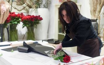 MADRID, SPAIN - FEBRUARY 13: An employee prepares a rose at the flower shop 'Margarita se llama mi Amor', one day before Valentine's Day, on 13 February, 2023 in Madrid, Spain. According to a study by Aladina.com, each Spaniard with a partner will spend an average of 80 euros on gifts for their partner. Most of them will buy only one gift, including flowers. Leisure and original experiences will be the star gifts this year, followed by classics such as clothing, accessories, footwear and perfumes. Every year, Spaniards buy more and more gifts exclusively online. (Photo By Gustavo Valiente/Europa Press via Getty Images)