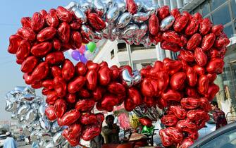 A Pakistani vendor prepares heart-shaped balloons for sale ahead of Valentine's day in Karachi on February 13, 2013. Valentine's Day is increasingly popular among younger Pakistanis, many of whom have taken up the custom of giving cards, chocolates and gifts to their sweethearts to celebrate the occasion. AFP PHOTO/Rizwan TABASSUM        (Photo credit should read RIZWAN TABASSUM/AFP via Getty Images)