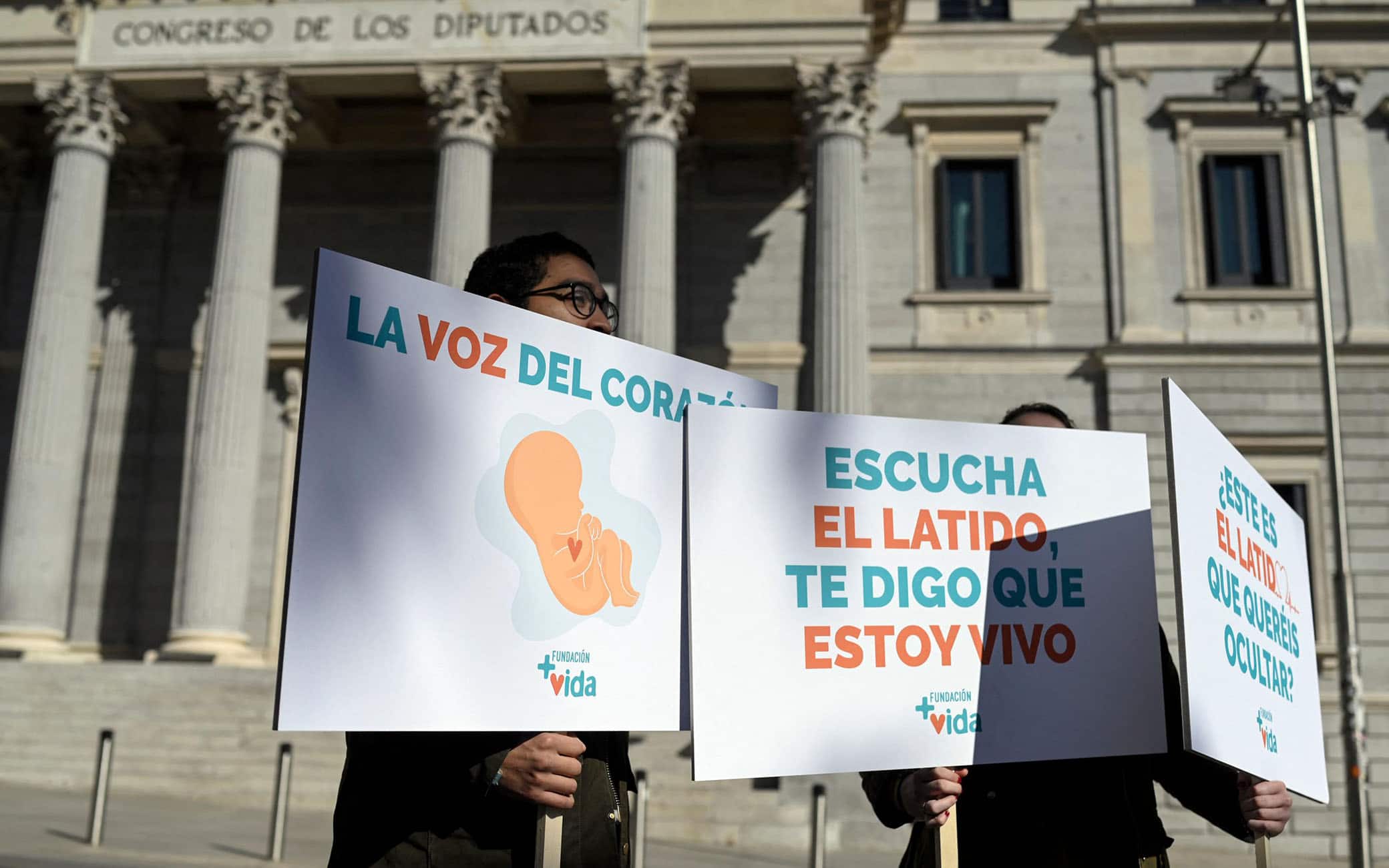 I manifestanti contro l'aborto protestano con striscioni con la scritta: "Il battito del mio cuore significa che sono vivo" davanti al Congresso spagnolo
