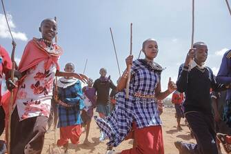 Youth from the Maasai community run to welcome US First Lady Jill Biden (not seen) during her visit to Loseti in Kajiado county, Kenya, on February 26, 2023 where she heard about the impoverishing impact of drought to the herder community during the third day of her visit to Kenya where she toured a drought response site to highlight the impacts of drought on communities. (Photo by Tony KARUMBA / AFP) (Photo by TONY KARUMBA/AFP via Getty Images)