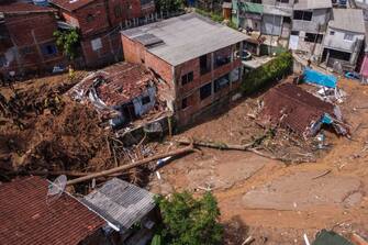 Aerial view showing rescuers in the destruction path left by a landslide after torrential rain in the Barra do Sahy district in Sao Sebastiao, Sao Paulo State, Brazil, on February 21, 2023. - Rescuers in southeastern Brazil scramble on February 22 to find survivors among dozens of people still missing after record rainfalls caused flooding and mudslides that killed at least 48 people over the weekend.  Some 680 millimeters (26 inches) of rain -- more than double the expected monthly amount -- fell in 24 hours around the popular beach city of Sao Sebastiao, some 200 kilometers (120 miles) southeast of Sao Paulo.  (Photo by Fernando MARRON/AFP) (Photo by FERNANDO MARRON/AFP via Getty Images)