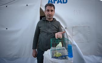KAHRAMANMARAS, TURKIYE - FEBRUARY 24: Mevlut KemahlÄ±, an earthquake survivor lives the tent city established in Vali Saim Cotur Stadium and around with his parakeets named "Limon and KÃ¶fte" after 7.7 and 7.6 magnitude earthquakes hit multiple provinces of Turkiye including Kahramanmaras on February 24, 2023. Some survivors of earthquakes in Kahramanmaras live together in a tent city with their animals, such as fish, birds, partridges, cats and dogs, which they rescued while leaving their homes. Established by the Sakarya 7th Commando Brigade Command, the tent city hosts nearly 3,500 earthquake victims as well as dozens of pets. (Photo by Fatih Kurt/Anadolu Agency via Getty Images)