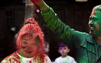 epa09830812 A young Nepalese woman is smeared with colors during the Holi Festival in Kathmandu, Nepal, 17 March 2022. Holi, also known as the 'Festival of Colors', marks the beginning of spring and is celebrated all over Nepal and neighboring India.  EPA/NARENDRA SHRESTHA