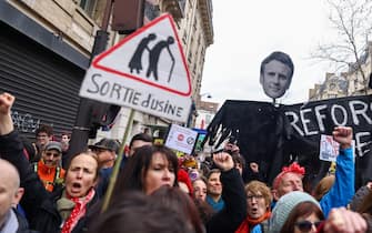 epaselect epa10507561 Protesters hold a banner showing French President Macron's face, during a protest against the French government's planned reform of the pension system, in Paris, France, 07 March 2023. The French government plans to delay the minimum retirement age from 62 to 64, until 2030.  EPA/MOHAMMED BADRA