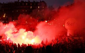 TOPSHOT - Demonstrators lights flares as they gahter in Place de la Bastille during a rally called by French trade unions in Paris on January 19, 2023. - A day of strikes and protests kicked off in France on January 19, set to disrupt transport and schooling across the country in a trial for the government as workers oppose a deeply unpopular pensions overhaul. (Photo by Thomas SAMSON / AFP) (Photo by THOMAS SAMSON/AFP via Getty Images)