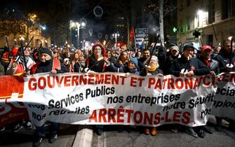 Protesters take part in a torch-lit march called by the CGT workers' union to protest the French government's pensions reform plan, on the Canebiere in Marseille, southeastern France, on January 17, 2023. - France is to face strikes across different sectors on January 19, 2023, as workers join a nationwide strike against a widely unpopular pension reform plan. The suggested changes, still to be debated in parliament, would raise the retirement age from 62 to 64 and increase contributions required for a full pension. (Photo by Nicolas TUCAT / AFP) (Photo by NICOLAS TUCAT/AFP via Getty Images)