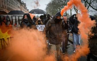 A demonstrator waves a smoke grenade during a rally called by French trade unions in Nantes, western France on January 19, 2023, as workers go on strike over the French President's plan to raise the legal retirement age from 62 to 64. - A day of strikes and protests kicked off in France on January 19, set to disrupt transport and schooling across the country in a trial for the government as workers oppose a deeply unpopular pensions overhaul. (Photo by LOIC VENANCE / AFP) (Photo by LOIC VENANCE/AFP via Getty Images)
