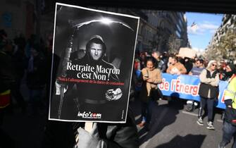 TOPSHOT - A protester holds a placard depicting French President Emmanuel Macron and reading "Macron's pension, it is a no" during a rally called by French trade unions against the government pension reform plan in Marseille, southern France, on January 19, 2023. - A day of strikes and protests kicked off in France on January 19, 2023 set to disrupt transport and schooling across the country in a trial for the government as workers oppose a deeply unpopular pensions overhaul. (Photo by NICOLAS TUCAT / AFP) (Photo by NICOLAS TUCAT/AFP via Getty Images)