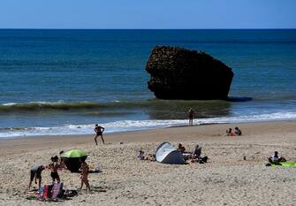 People sunbathe at Matalascanas beach, in Almonte, due to the good weather and high temperatures, on March 11, 2023. (Photo by CRISTINA QUICLER / AFP) (Photo by CRISTINA QUICLER/AFP via Getty Images)