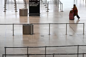 epa10519575 A passenger walks at an empty Terminal of the Berlin-Brandenburg airport, Germany, 13 March 2023. The employees of aviation security and ground handling services called for a 24 hours strike over wages.  EPA/FILIP SINGER