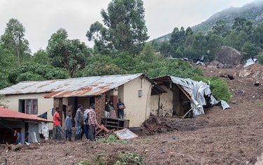 People stand near the destruction caused by mudslide which occurred due to heavy rains resulting from the effects of tropical cyclone freddy, that left hundreds of people dead in Malawi, pictured during Malawi Defence Force, (MDF) soldiers operation to rescue victims or  recover their bodies at Manje informal settlement in Blantyre, southern Malawi on March 16, 2023. - As the rains ceased for the first time in five days, Malawi began the process of recovering bodies from cyclone Freddy-induced mudslides.
A joint operation by the military and members of the local communities recovered five bodies on March 16, 2023 from the mud. (Photo by Amos Gumulira / AFP) (Photo by AMOS GUMULIRA/AFP via Getty Images)