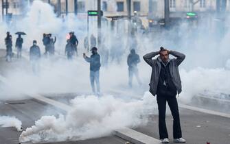 A protester stand in tear gas during a demonstration after the French government pushed a pensions reform through parliament without a vote, using the article 49.3 of the constitution, in Nantes, western France, on March 18, 2023. The French president on March 16 rammed a controversial pension reform through parliament without a vote, deploying a rarely used constitutional power that risks inflaming protests. The move was an admission that his government lacked a majority in the National Assembly to pass the legislation to raise the retirement age from 62 to 64.//SALOM-GOMIS_n036/Credit:Sebastien SALOM-GOMIS/SIPA/2303182022