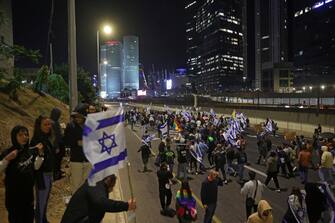 ISRAEL PROTEST epa10530881 Protesters block the Ayalon main highway during a protest march against the government's justice system reform plans in Tel Aviv, Israel, 18 March 2023. Nationwide protests against the government's judicial reform plans are being held for eleven weeks in a row. Israel's parliament passed a draft law limiting the power of the Israeli Supreme Court in a first reading on 14 March. EPA/ABIR SULTAN