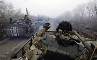 TOPSHOT - A convoy of Ukrainian forces drives to Debaltseve, Donetsk region, on February 14, 2015. Fighting has raged on in Ukraine, throwing doubts on a ceasefire deal due to take effect over the weekend, with the US saying Russia is still deploying heavy arms and Kiev warning that shelling of civilians had intensified.AFP PHOTO/ ANATOLII STEPANOV (Photo by ANATOLII STEPANOV / AFP) (Photo by ANATOLII STEPANOV/AFP via Getty Images)