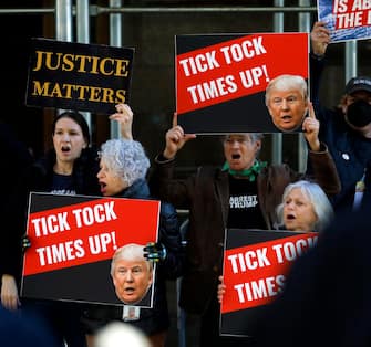epa10535215 Demonstrators shout and hold up signs outside New York Criminal Court in advance of a potential Indictment of former President Donald Trump in New York, New York, USA, 21 March 2023. Major US News organizations continue to report the likelihood that former President Donald J. Trump may be the first US President to be formally indicted on charges related to hush-money payments to porn star Stormy Daniels.  EPA/Peter Foley