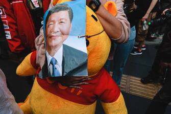 BANGKOK, THAILAND - 2022/11/17: A protester holds a pooh bear with a poster of Xi Jinping during the demonstration.  Pro-democracy protesters gathered at Asok intersection near Queen Sirikit National Convention Center (QSNCC) where APEC is being held to protest in Bangkok.  (Photo by Varuth Pongsapipatt/SOPA Images/LightRocket via Getty Images)