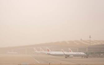 BEIJING, CHINA - MARCH 22: Planes are seen at Beijing Capital International Airport during a sandstorm on March 22, 2023 in Beijing, China. (Photo by VCG/VCG via Getty Images)
