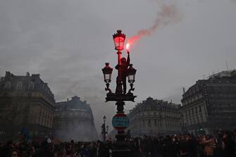 epaselect epa10539134 A protester lights a flair as thousands of people participate in a protest against the government's reform of the pension system in Paris, France, 23 March 2023. Protests continue in France after the prime minister announced on 16 March 2023 the use of Article 49 paragraph 3 (49.3) of the French Constitution to have the text on the controversial pension reform law - raising retirement age from 62 to 64 - be definitively adopted without a vote.  EPA/MOHAMMED BADRA