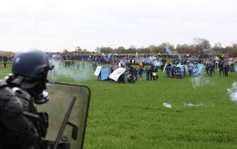Protesters clash with riot mobile gendarmes during a demonstration called by the collective "Bassines non merci", the environmental movement "Les Soulevements de la Terre" and the French trade union 'Confederation paysanne' to protest against the construction of a new water reserve for agricultural irrigation, in Sainte-Soline, central-western France, on March 25, 2023. - More than 3,000 police officers and gendarmes have been mobilised and 1,500 "activists" are expected to take part in the demonstration, around Sainte-Soline. The new protest against the "bassines", a symbol of tensions over access to water, is taking place under thight surveillance on March 25, 2023 in the Deux-Sevres department. (Photo by Yohan Bonnet / AFP) (Photo by YOHAN BONNET/AFP via Getty Images)