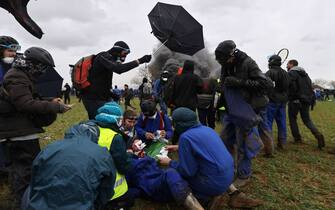 A wounded protester is under care during a demonstration called by the collective "Bassines non merci", the environmental movement "Les Soulevements de la Terre" and the French trade union 'Confederation paysanne' to protest against the construction of a new water reserve for agricultural irrigation, in Sainte-Soline, central-western France, on March 25, 2023. - More than 3,000 police officers and gendarmes have been mobilised and 1,500 "activists" are expected to take part in the demonstration, around Sainte-Soline. The new protest against the "bassines", a symbol of tensions over access to water, is taking place under thight surveillance on March 25, 2023 in the Deux-Sevres department. (Photo by Thibaud MORITZ / AFP) (Photo by THIBAUD MORITZ/AFP via Getty Images)