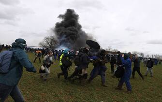 Protesters evacuate a wounded demonstrator during a rally called by the collective "Bassines non merci", the environmental movement "Les Soulevements de la Terre" and the French trade union 'Confederation paysanne' to protest against the construction of a new water reserve for agricultural irrigation, in Sainte-Soline, central-western France, on March 25, 2023. - More than 3,000 police officers and gendarmes have been mobilised and 1,500 "activists" are expected to take part in the demonstration, around Sainte-Soline. The new protest against the "bassines", a symbol of tensions over access to water, is taking place under thight surveillance on March 25, 2023 in the Deux-Sevres department. (Photo by Thibaud MORITZ / AFP) (Photo by THIBAUD MORITZ/AFP via Getty Images)