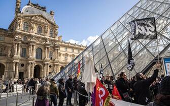 epa10545215 Louvre Museum employees block the museum's entrance during a demonstration in front of the Louvre Pyramide to protest against the government pension reform in Paris, France, 27 March 2023. France faces an ongoing national strike against the government's pensions reform after Prime Minister Elisabeth Borne on 16 March announced the use of article 49 paragraph 3 (49.3) of the Constitution of France to have the text on the controversial pension reform law to be definitively adopted without a vote.  EPA/CHRISTOPHE PETIT TESSON