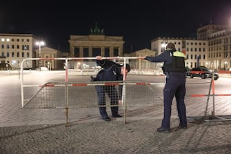 29 March 2023, Berlin: Police forces set up a fence on Pariser Platz in front of the Brandenburg Gate for King Charles III's visit to Berlin.  Photo: Joerg Carstensen/dpa (Photo by Joerg Carstensen/picture alliance via Getty Images)