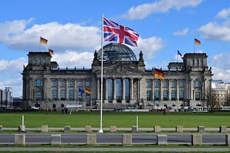 The Union Jack flies in front of the Reichstag building that houses the Bundestag (lower house of parliament) in Berlin on March 28, 2023, ahead of the visit of Britain's King Charles III to the German capital.  - Britain's King Charles III will begin his first state visit when he travels to Germany on March 29, 2023, having postponed a trip to France due to widespread political protests.  Charles will arrive in Berlin and undertake engagements there and in Brandenburg before heading to Hamburg during the three-day tour.  (Photo by JOHN MACDOUGALL/AFP) (Photo by JOHN MACDOUGALL/AFP via Getty Images)