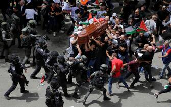 Israeli police clash with mourners as they carry the coffin of slain Al Jazeera journalist Shireen Abu Akleh during her funeral in east Jerusalem, on May 13, 2022. Abu Akleh, a Palestinian-American reporter who covered the Mideast conflict for more than 25 years, was shot dead two days earlier during an Israeli military raid in the West Bank town of Jenin. (AP Photo/Maya Levin)
