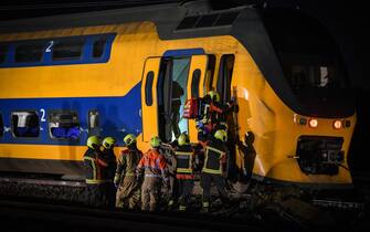 epa10557657 Emergency services work at a site of a derailed night train in Voorschoten, The Netherlands, 04 April 2023. One person has died and several people were seriously injured after a passenger train collided with construction equipment on the tracks.  A freight train was also involved in the accident.  EPA/REMKO DE WAAL