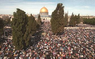 JER03-19980123-JERUSALEM: Palestinians perform Friday noon prayers at Jerusalem's Al-Aqsa mosque compound, in front of the Dome of the Rock, on the last Friday of the Islamic holy month of Ramadan 23 January.  More than a quarter of a million Muslims attended the prayers under heavy Israeli security.  EPA PHOTO/AFP AWAD AWAD