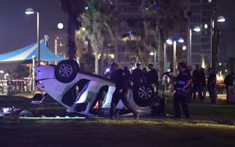 epa10564160 Israeli policemen work at the scene of a shooting and ramming attack in Tel Aviv, Israel, 07 April 2023. According to Israeli police, one tourist was shot and killed and five others were injured when a driver rammed his car into passers-by on the beach promenade of Tel Aviv.  EPA/ABIR SULTAN