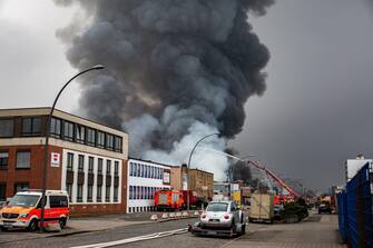 epa10566211 Firefighters try to extinguish a fire burning at a warehouse in the Rothenburgsort district of Hamburg, Germany, 09 April 2023. Residents have been warned of heavy smoke and possible toxins in the air.  An alert issued by the Hamburg fire department said smoke gases and chemical components in the air could affect breathing.  EPA/DOMINICK WALDECK