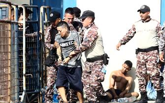 GUAYAQUIL, ECUADOR - APRIL 14: A handcuffed inmate is taken by guards after a riot on April 14, 2023 in Guayaquil, Ecuador.  Authorities report at least 3 injured inmates after a fight inside the 'Centro de RehabilitaciÛn Social de Varones N. 1 de Guayaquil known as the 'Del Litoral Prison'.  Official reports mention that the situation has been controlled.  (Photo by Gerardo Menoscal/Agencia Press South/Getty Images)