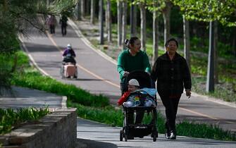 People walk in a public park in Beijing on April 15, 2023. (Photo by WANG Zhao / AFP) (Photo by WANG ZHAO/AFP via Getty Images)