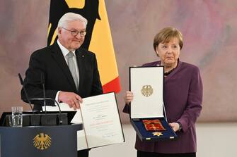 epa10577205 Former German Chancellor Angela Merkel (R) poses after after she was awarded the 'Grand Cross of the Order of Merit of the Federal Republic of Germany' by German President Frank-Walter Steinmeier (L) during a ceremony in Berlin, Germany, 17 April 2023. EPA/FILIP SINGER