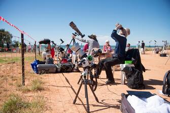 epa10581224 People gather with optical equipment ahead of a total solar eclipse at a viewing site 24km from Exmouth, Western Australia, Australia, 20 April 2023. The total solar eclipse will occur on a remote peninsula on the Western Australian coast.  EPA/AARON BUNCH AUSTRALIA AND NEW ZEALAND OUT