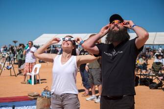 epa10581275 People use solar viewing glasses to watch a total solar eclipse at a viewing site near Exmouth, Western Australia, Australia, 20 April 2023. EPA/AARON BUNCH AUSTRALIA AND NEW ZEALAND OUT