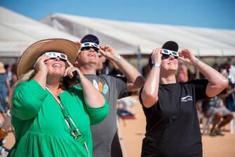 epa10581222 People use solar viewing glasses to look up at the sky ahead of a total solar eclipse at a viewing site 24km from Exmouth, Western Australia, Australia, 20 April 2023. The total solar eclipse will occur on a remote peninsula on the Western Australian coast .  EPA/AARON BUNCH AUSTRALIA AND NEW ZEALAND OUT