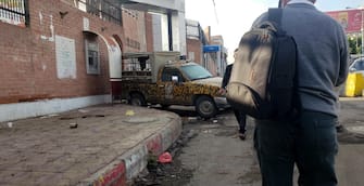epa10581310 A man passes a police vehicle parked at the gate of a hospital in which several people injured in a deadly stampede are receiving treatment, in Sana'a, Yemen, 20 April 2023. At least 80 people, including women and children, were killed and dozens more wounded in a crowd crush in the Yemeni capital Sana'a after a Ramadan alms donation sparked a stampede.  EPA/YAHYA ARHAB