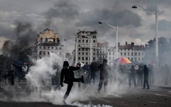Protesters walk among teargas during a demonstration on May Day (Labour Day) to mark the international day of the workers, more than a month after the government pushed an unpopular pensions reform act through parliament, in Lyon, eastern France, on May 1, 2023. - Opposition parties and trade unions have urged protesters to maintain their three-month campaign against the law that will hike the retirement age to 64 from 62. (Photo by JEFF PACHOUD / AFP) (Photo by JEFF PACHOUD/AFP via Getty Images)