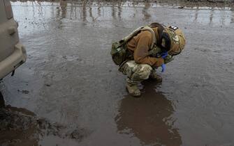 TOPSHOT - Nurse Liana, 25, from the Da Vinci Wolves Battalion waits the evacuation of a wounded Ukrainian serviceman near the front line of Bakhmut, on April 1, 2023, amid the Russian invasion of Ukraine.  - Churned-up roads have been turned into quagmires by melted snow, making the journey slow.  The ambulance is coated in mud from wheels to roof.  (Photo by Genya SAVILOV/AFP) (Photo by GENYA SAVILOV/AFP via Getty Images)