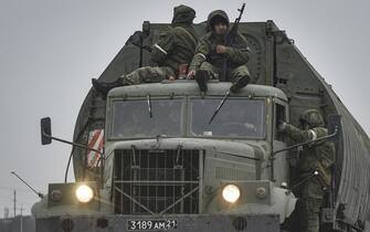 epa09784377 Russian troops move towards Ukraine on the road near Armiansk, Crimea, 25 February 2022. Russian troops entered Ukraine on 24 February prompting the country's president to declare martial law and triggering a series of announcements by Western countries to impose severe economic sanctions on Russia.  EPA/STRINGER