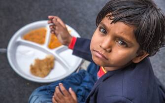 Indian school children eat their free midday meal at a government school in Haryana