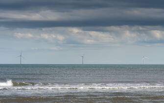 Offshore wind turbines seen from the beach at Cambois, Blyth, Northumberland, UK. Credit: Hazel Plater/Alamy